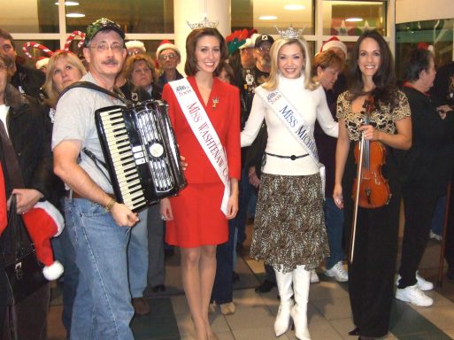 Tom Brown and his accordion , standing with several pageant contestants.