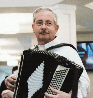 A photo of Tom Brown playing his accordion.